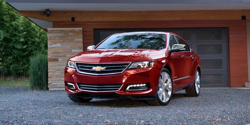Red 2020 Chevy Impala in front of nice home